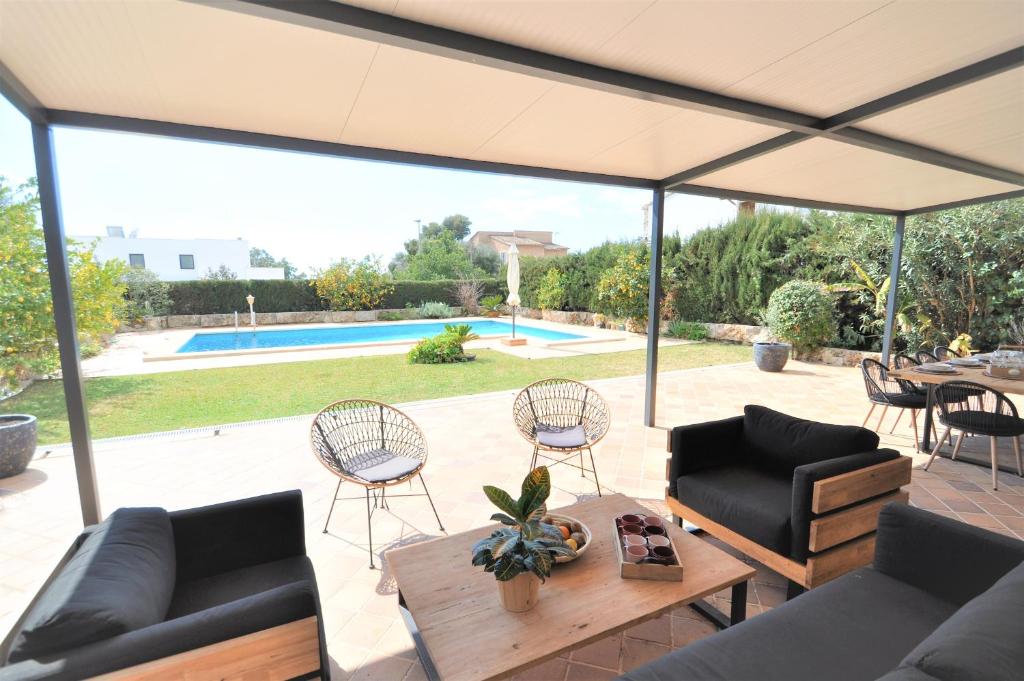 patio z kanapami, stołem i krzesłami w obiekcie Hermosa casa de vacaciones CA NA MALEN w mieście La Cabaneta