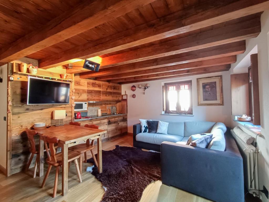 a living room with a blue couch and a table at La Maison des myrtilles - Bluchalet in La Thuile