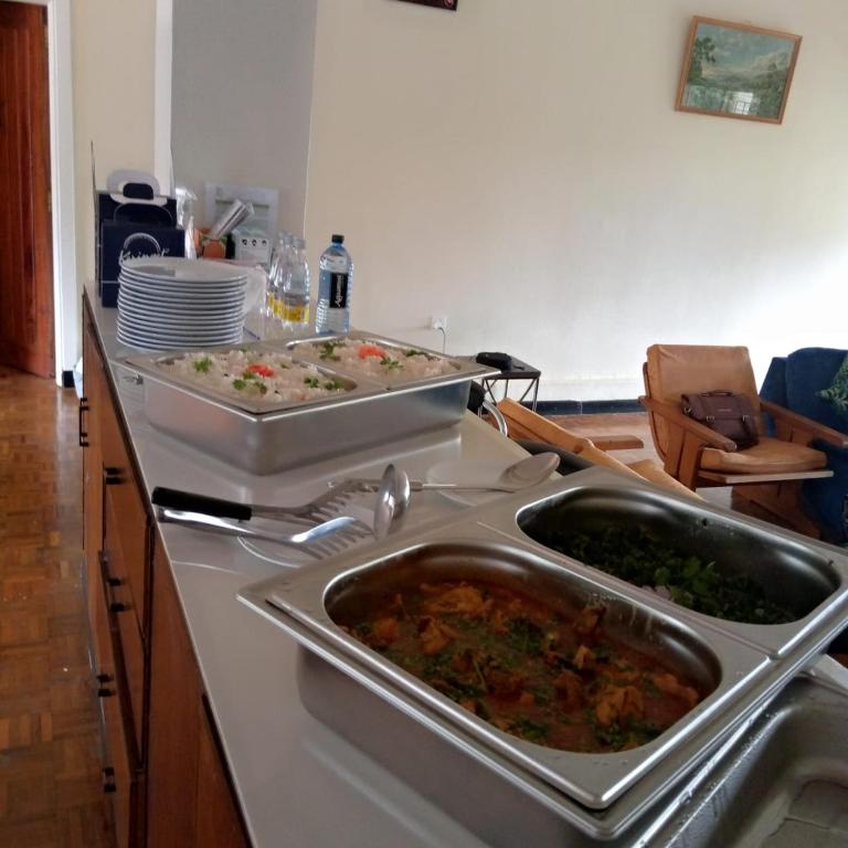 a kitchen with two trays of food on a counter at Thayo Place in Nyeri