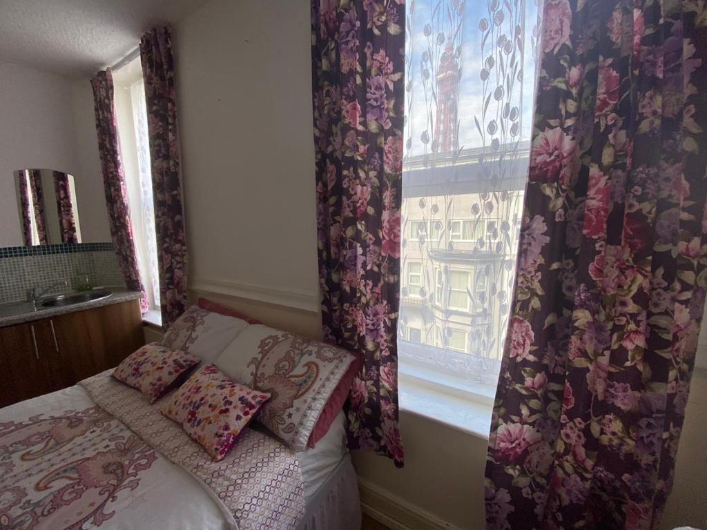 a small bedroom with a bed and a window at Mellory hotel in Blackpool