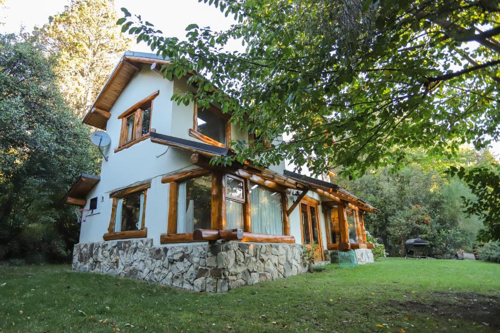 a house with a stone facade and windows at Al pie del Campanario in San Carlos de Bariloche
