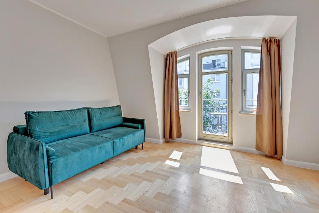 a living room with a green couch and a window at Grand Apartments - Lemon - Monte Cassino in Sopot