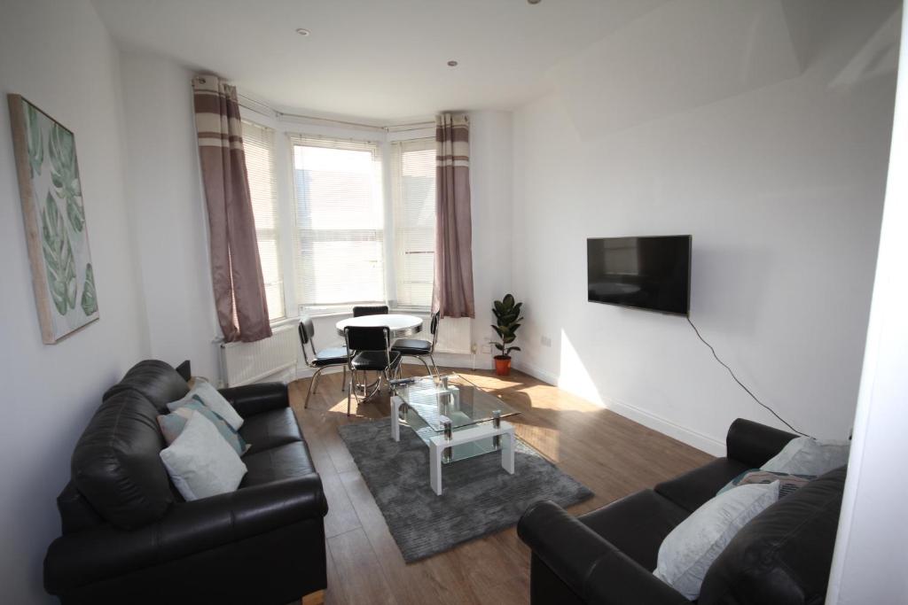 a living room with a couch and a table at Harlesden Road Place in London