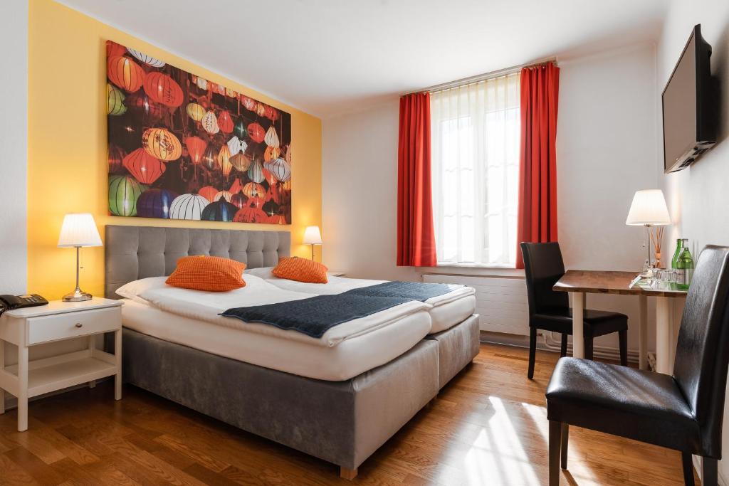 1 dormitorio con 1 cama con una pintura en la pared en Hotel Murten, en Murten