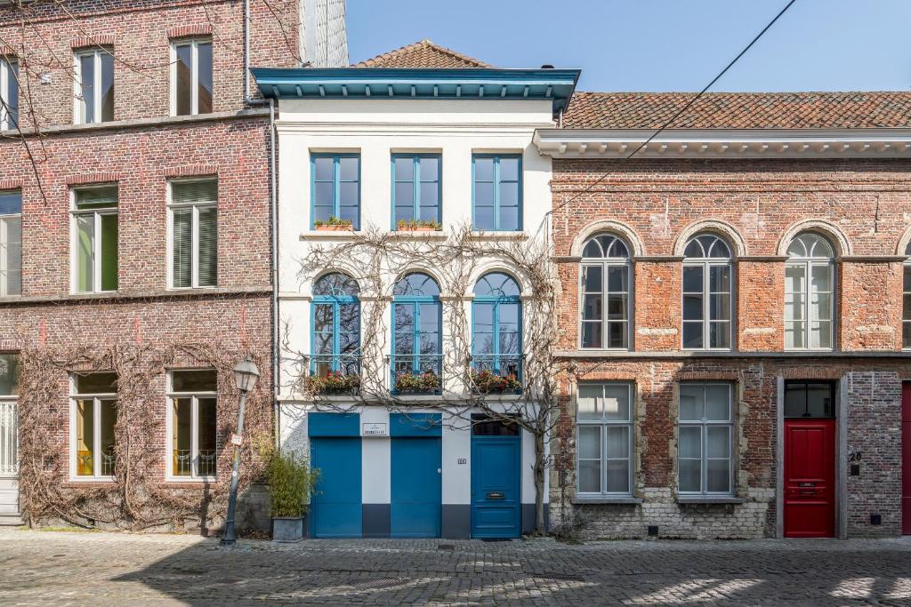 een oud bakstenen gebouw met blauwe deuren en ramen bij TOP& ruim duplex woning in PATERSHOL,centrum Gent! in Gent