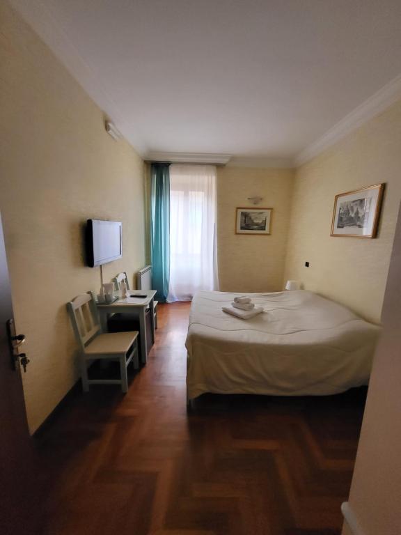 ein Hotelzimmer mit einem Bett, einem Schreibtisch und einem Fenster in der Unterkunft St. Peter's Rooms Rome in Rom