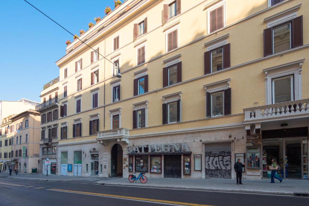 duży żółty budynek przy ulicy miejskiej w obiekcie Bramble Luxury Suites w Rzymie