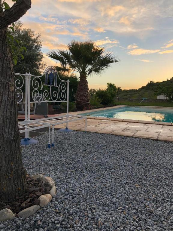 a fence next to a swimming pool with a tree at Monte de Stª Margarida II in Montemor-o-Novo