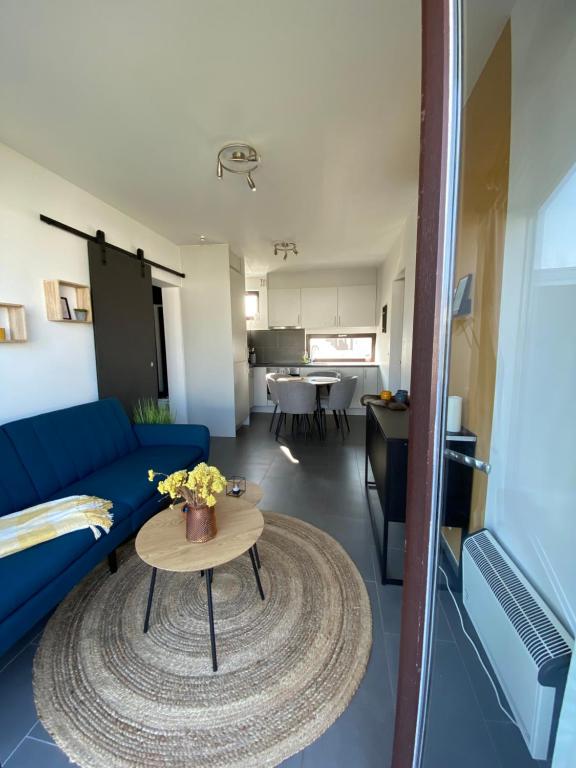 a living room with a blue couch and a table at Maison Lunette in Koksijde