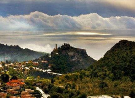 une ville sur une colline avec un château sur une montagne dans l'établissement Auberge de la Croix du Pape, à Èze