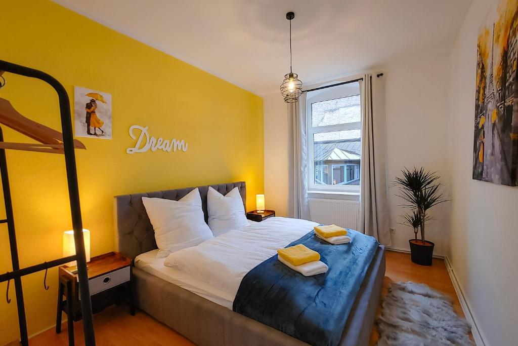 a bedroom with a large bed with yellow walls at M-OASE Wohlfühlen an der Oker I Küche I Netflix in Braunschweig