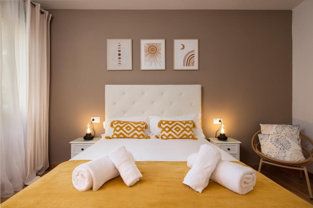 Un dormitorio con una cama con toallas blancas. en Villa Araucana en Cádiz