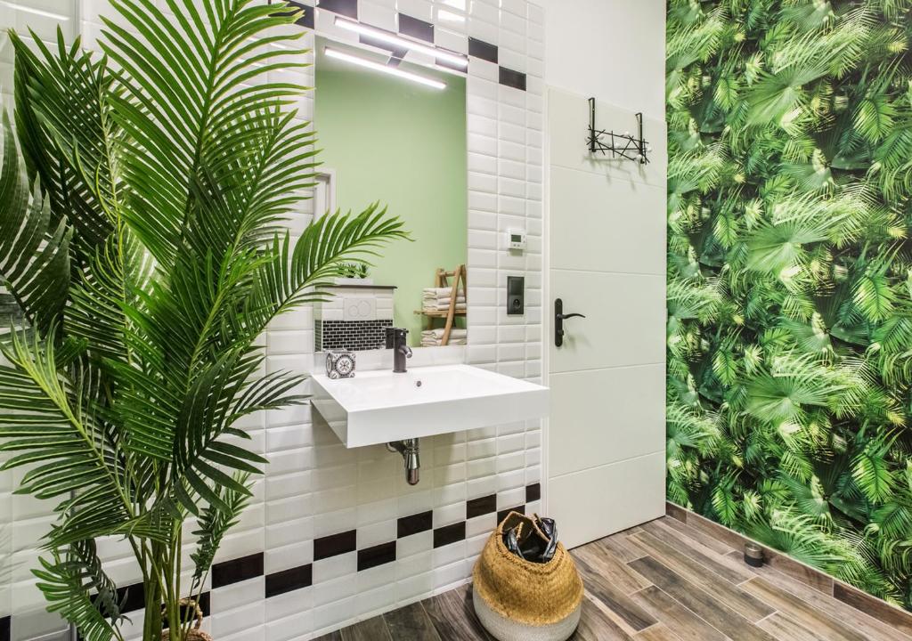 La salle de bains est pourvue d'un lavabo et d'une plante. dans l'établissement Le Dortoir des Templiers, à Enquin-les-Mines