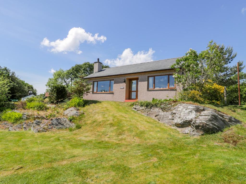 a house on a hill with a yard at Ceris in Penrhyndeudreath