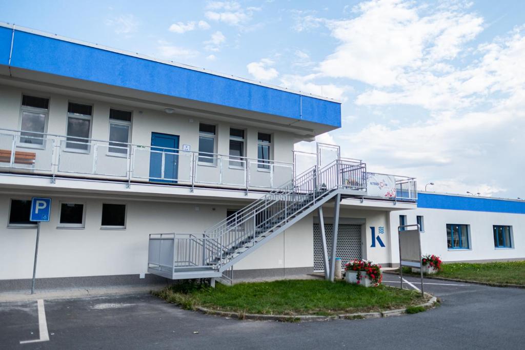 a white building with a staircase on the side of it at Ubytovna a Cykloubytovna Koupaliště Kadaň in Kadaň