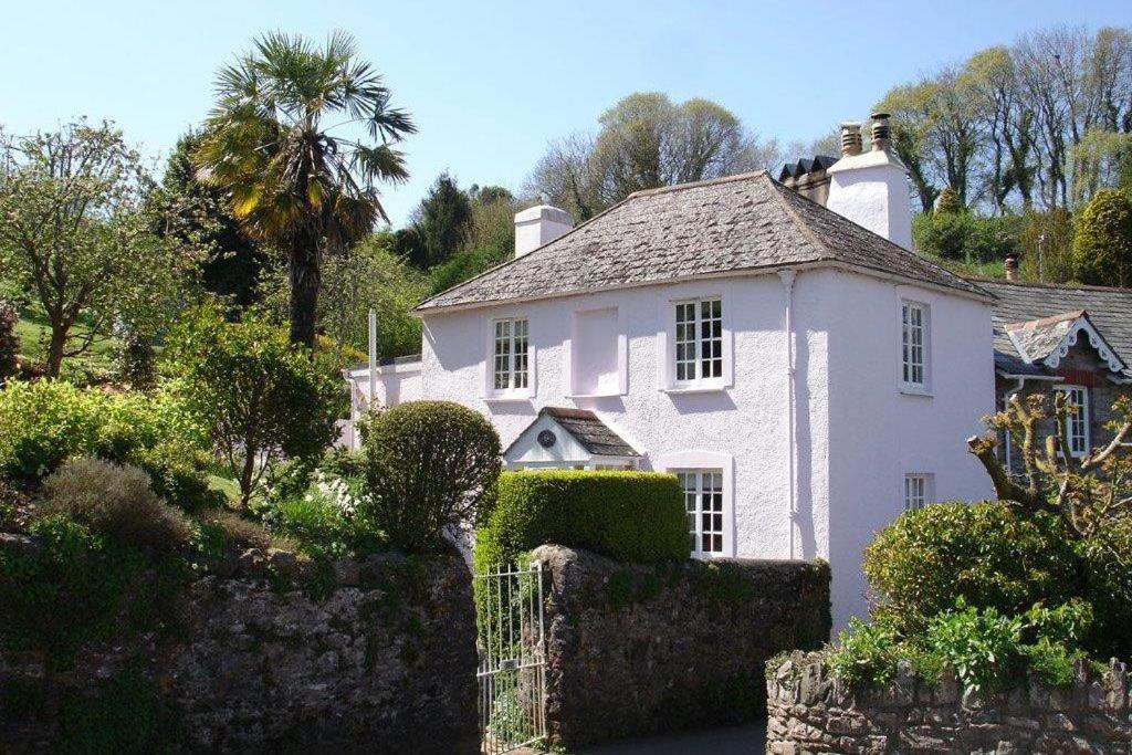 a white house with a fence in front of it at Thornwell Cottage - Heart of the village, amazing gardens, glorious views and brimming with character in Dittisham