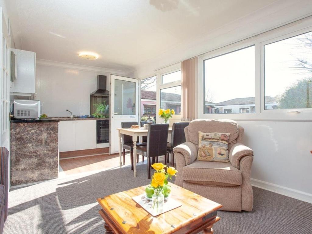 a living room with a chair and a table at Dawlish Warren Holidays in Dawlish