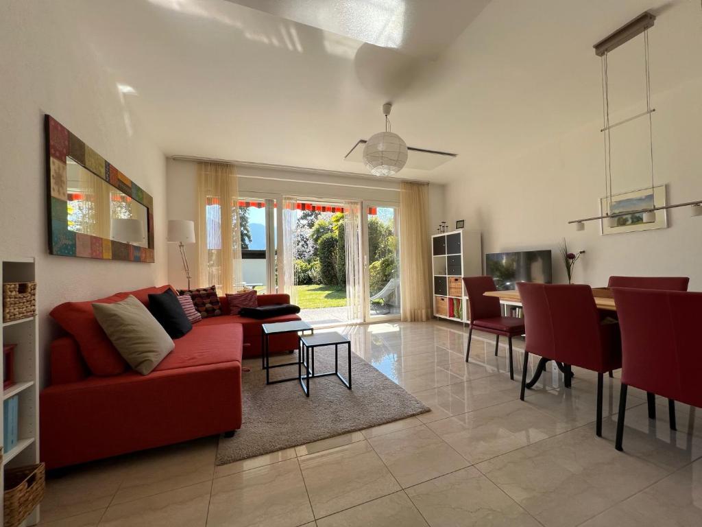 sala de estar con sofá rojo y mesa en Muralto - Locarno: Miramonti Apt.5 en Muralto