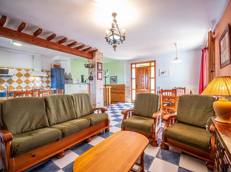 sala de estar con sofá, sillas y mesa en Casa Levante - Casa Rural Los Cuatro Vientos, en Moratalla