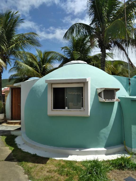 Casa con cúpula azul, ventana y palmeras en Cabanas de Tucuns en Búzios