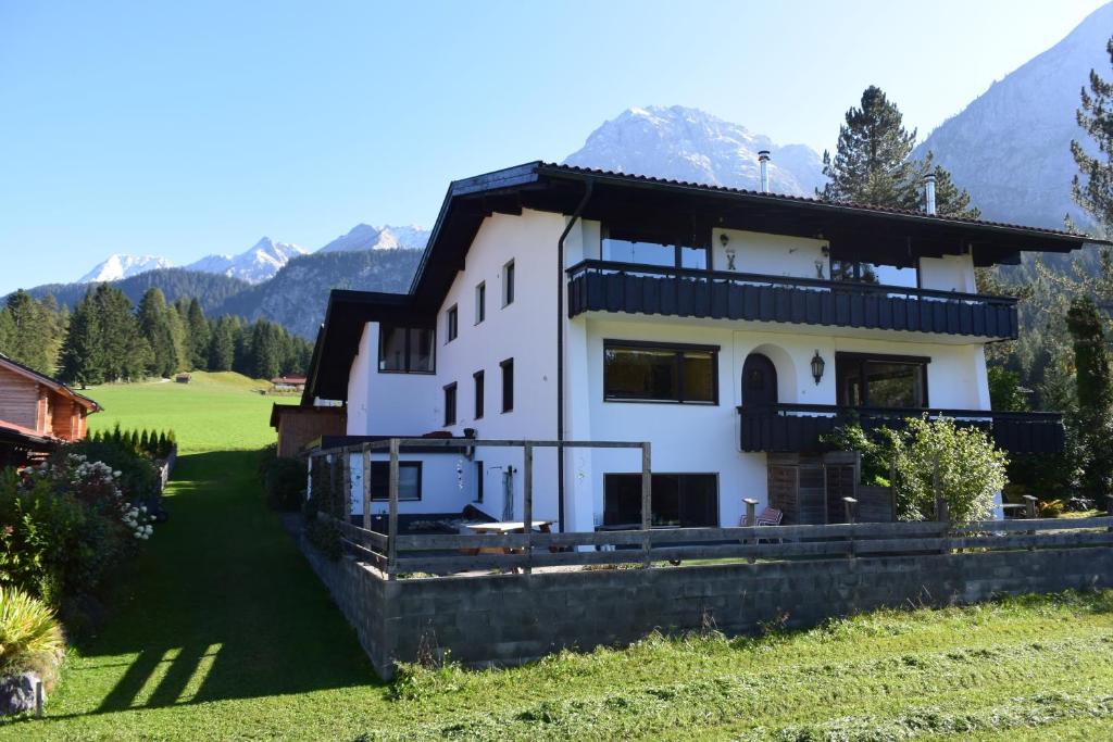 a large white house with mountains in the background at Appartement Liesl, ruim 4 pers. appartement met eigen tuin! in Ehrwald