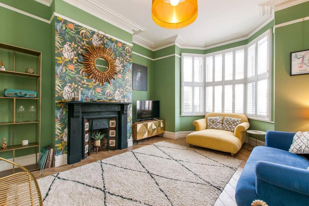 sala de estar con paredes verdes y chimenea en Chic Edwardian Home With Garden en Kent