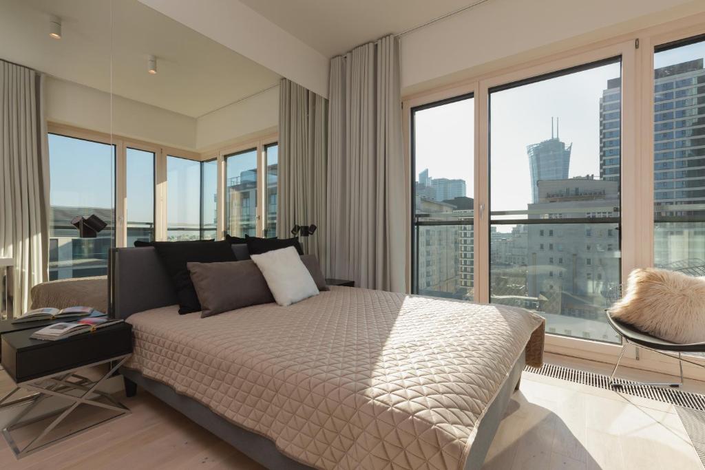 a bedroom with a bed with a view of a city at Mennica Residence Luxury Suite by Renters Prestige in Warsaw