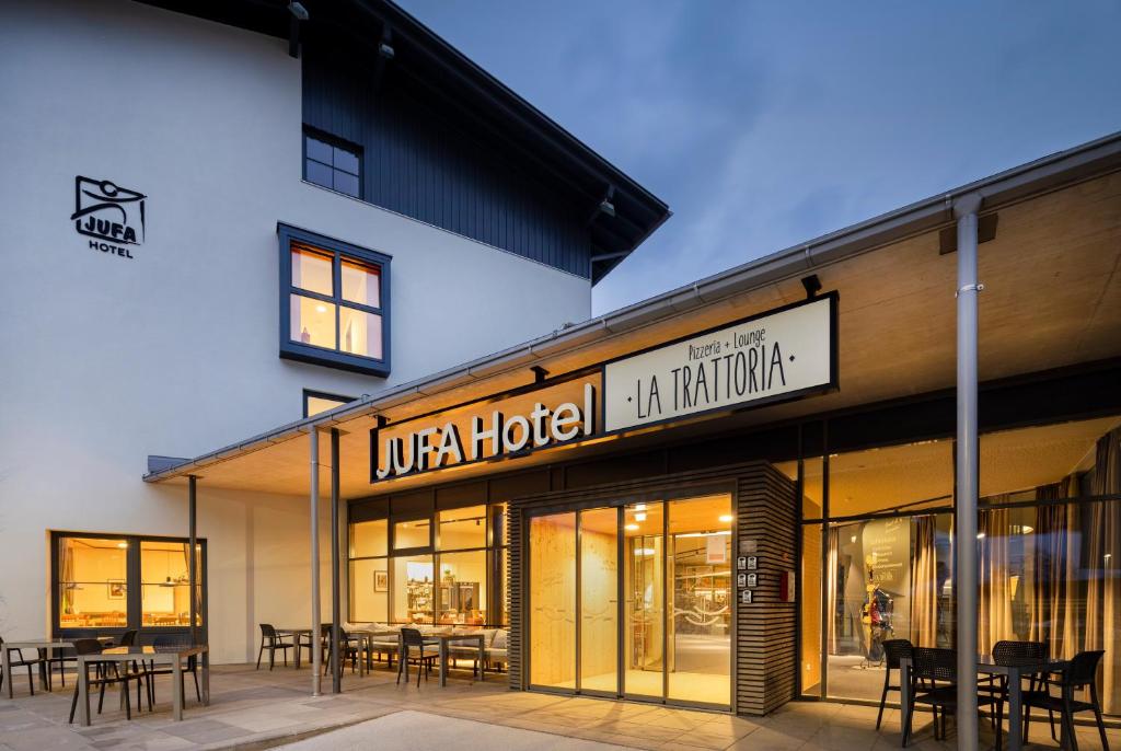 a store front of a hotel with tables and chairs at JUFA Hotel Wipptal in Steinach am Brenner