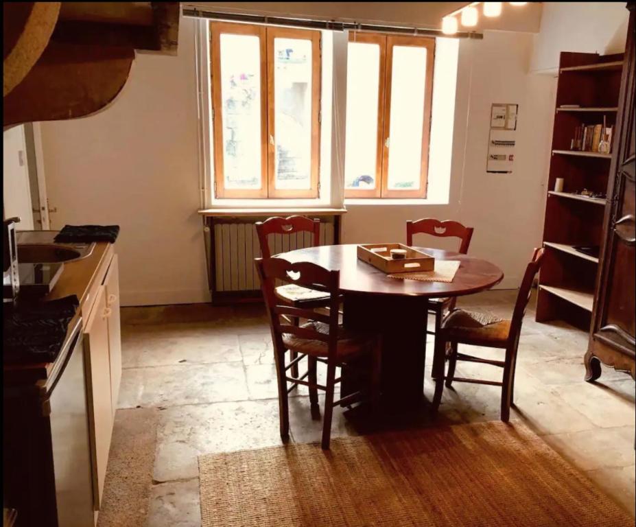 eine Küche mit einem Tisch und Stühlen im Zimmer in der Unterkunft Joli studio de caractère in Gray
