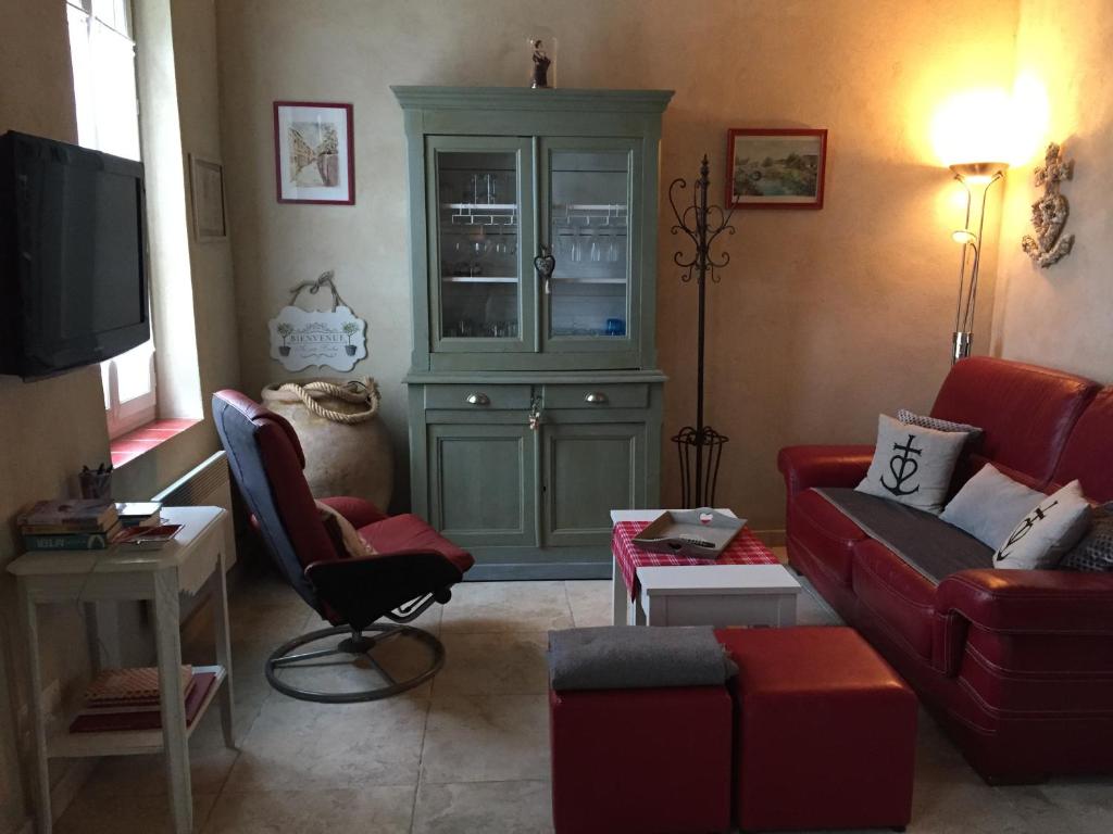 una sala de estar con muebles rojos y una cabaña verde en Maison au bord de mer en Saintes-Maries-de-la-Mer