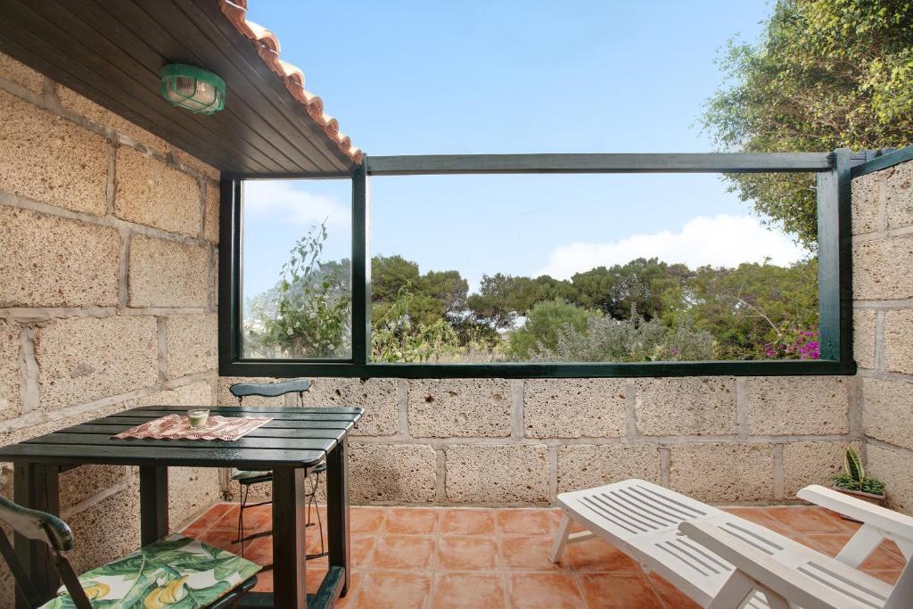 een patio met een tafel en stoelen en een raam bij Casa Inti in Granadilla de Abona