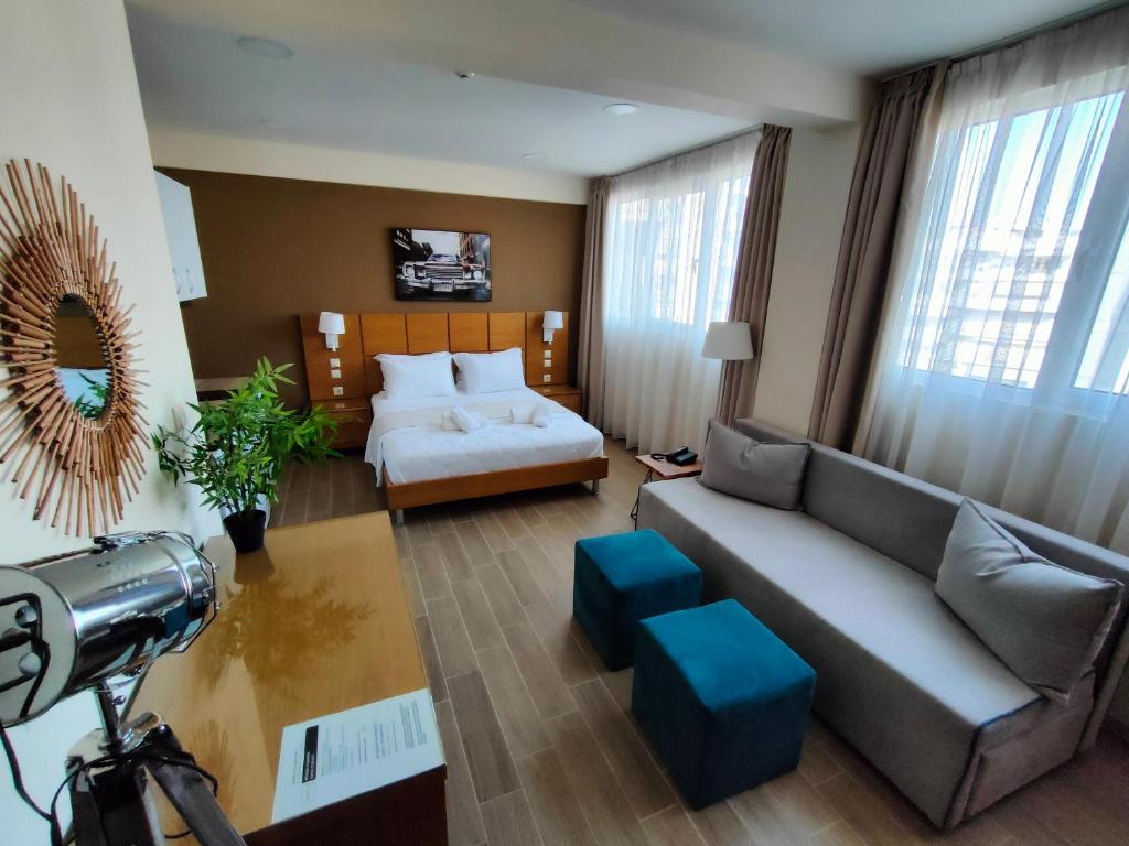 a living room with a couch and a bed at La Place Suites - La Place De La Gare in Thessaloniki