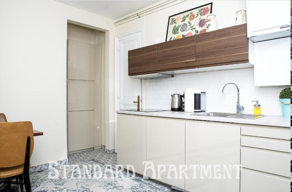 a kitchen with white cabinets and a sink at Eiffel Tower view Residence in Paris