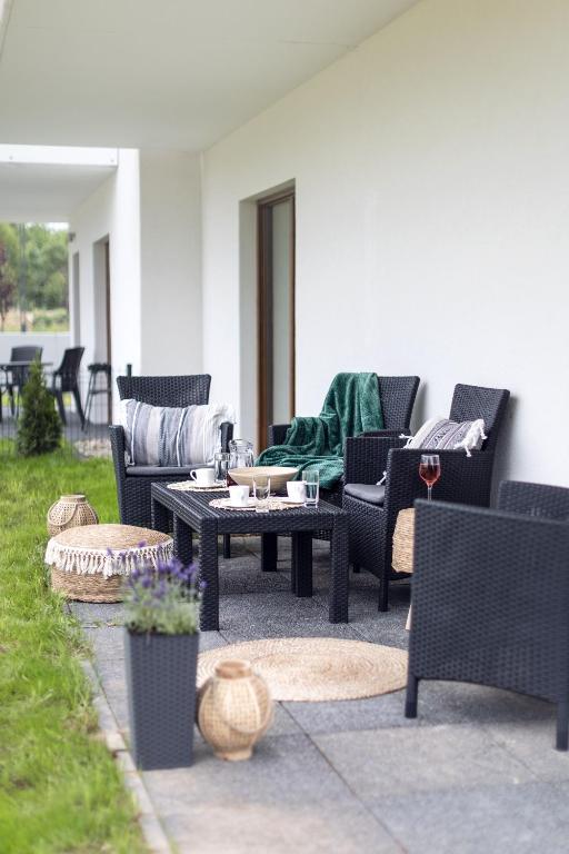 Long patio terrace with black wicker chairs, coffee table, decorative lanterns, potted lavender