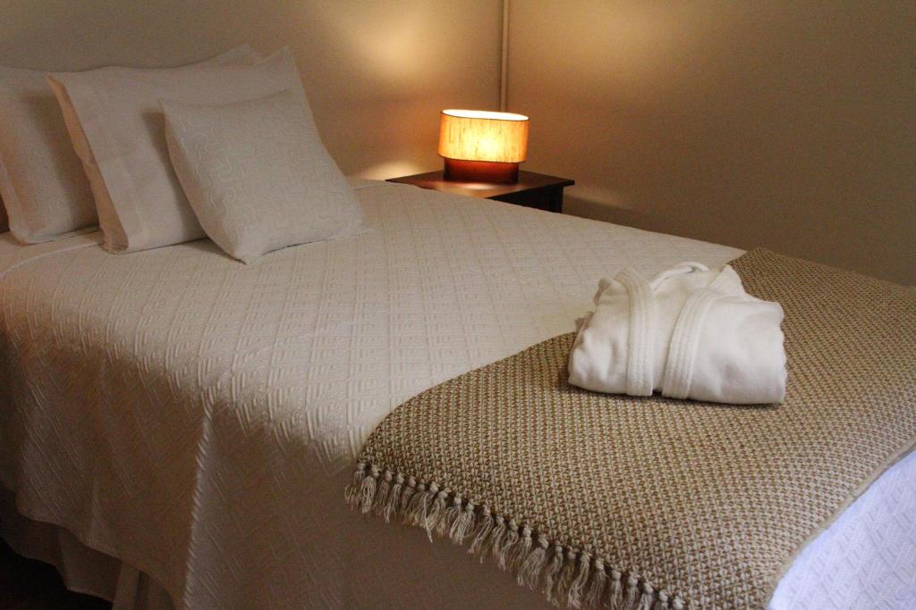 a white bed with a white pillow and a lamp at Hotel Boutique Casa Conde in Santiago