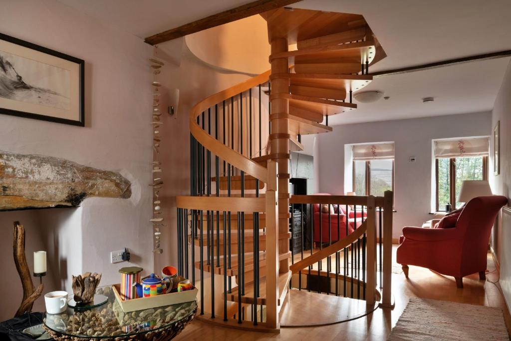 a wooden spiral staircase in a living room at Finest Retreats - Dolwar Cottage in Ffestiniog