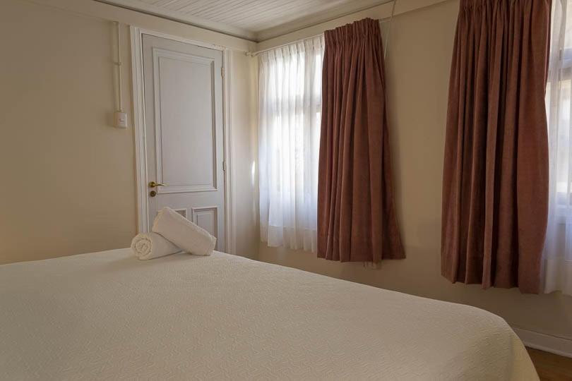 a bedroom with a white bed and a window at Hotel Boutique Casa Conde in Santiago