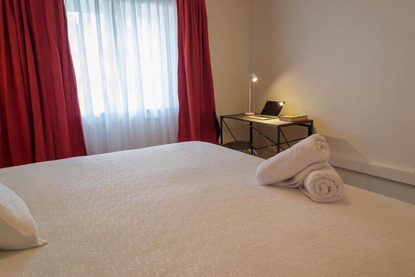 a bedroom with a bed and a desk with a laptop at Hotel Boutique Casa Conde in Santiago