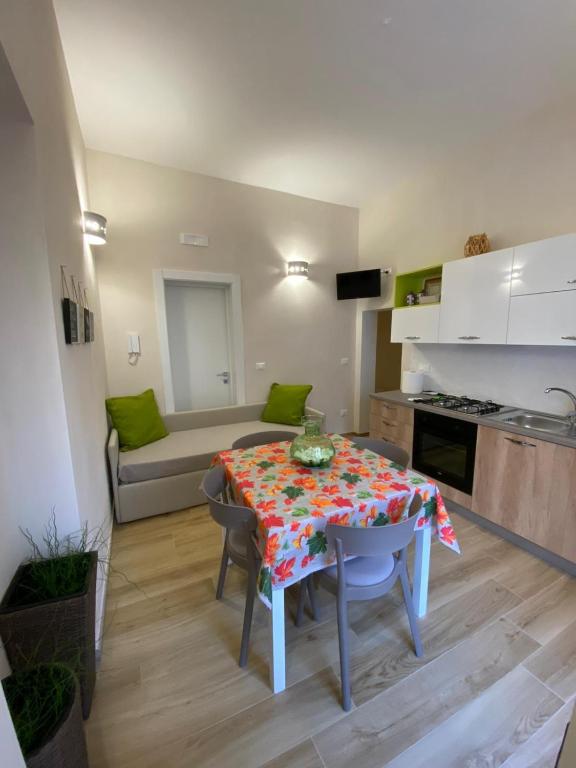 a living room with a table and a kitchen at La maison del porto in San Foca