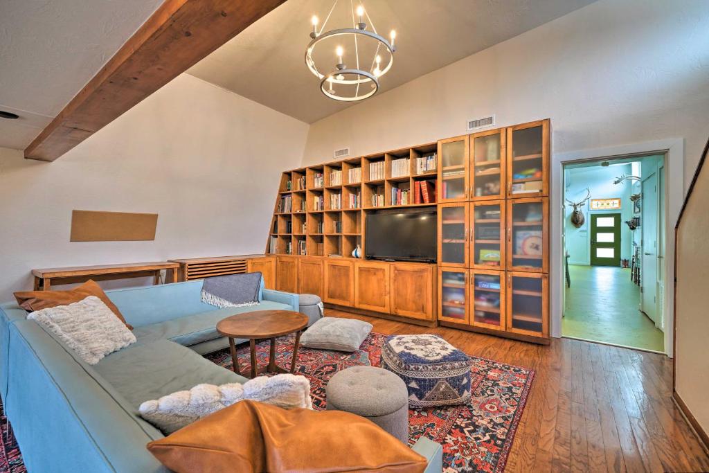 ein Wohnzimmer mit einem blauen Sofa und einem TV in der Unterkunft Bohemian Home with Screened Porch, 3 Mi to Lake! in Stillwater