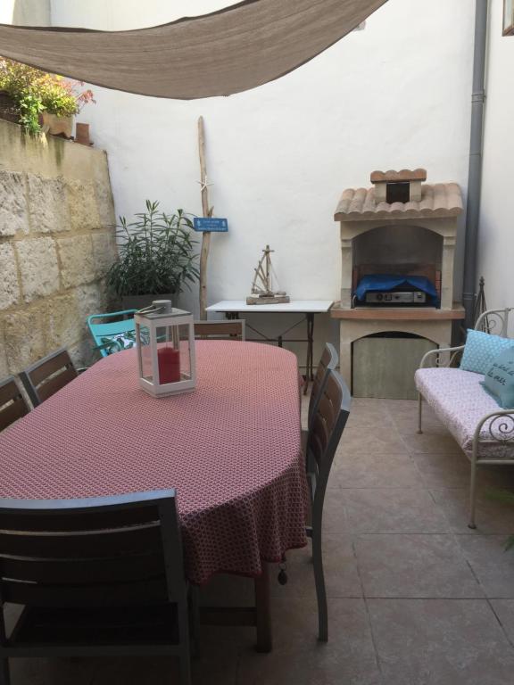 a table and chairs in a room with a pizza oven at Maison au bord de mer in Saintes-Maries-de-la-Mer