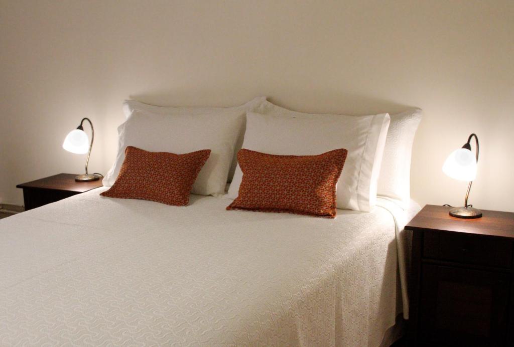 a white bed with two pillows and two lamps at Hotel Boutique Casa Conde in Santiago