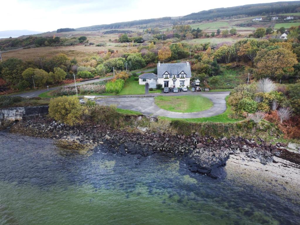 an aerial view of a house next to a body of water at Lochaline Hotel in Lochaline
