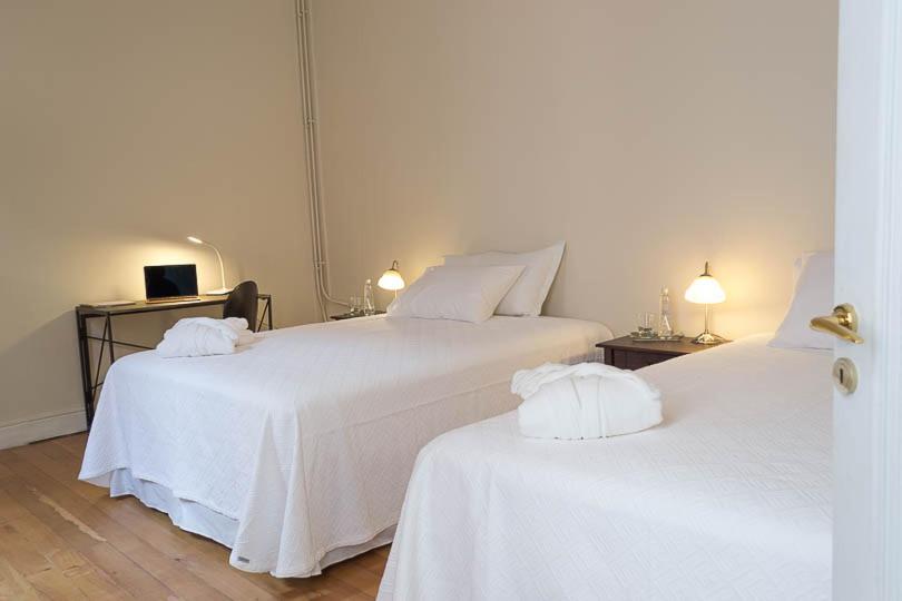 
a hotel room with two beds and two lamps at Hotel Boutique Casa Conde in Santiago
