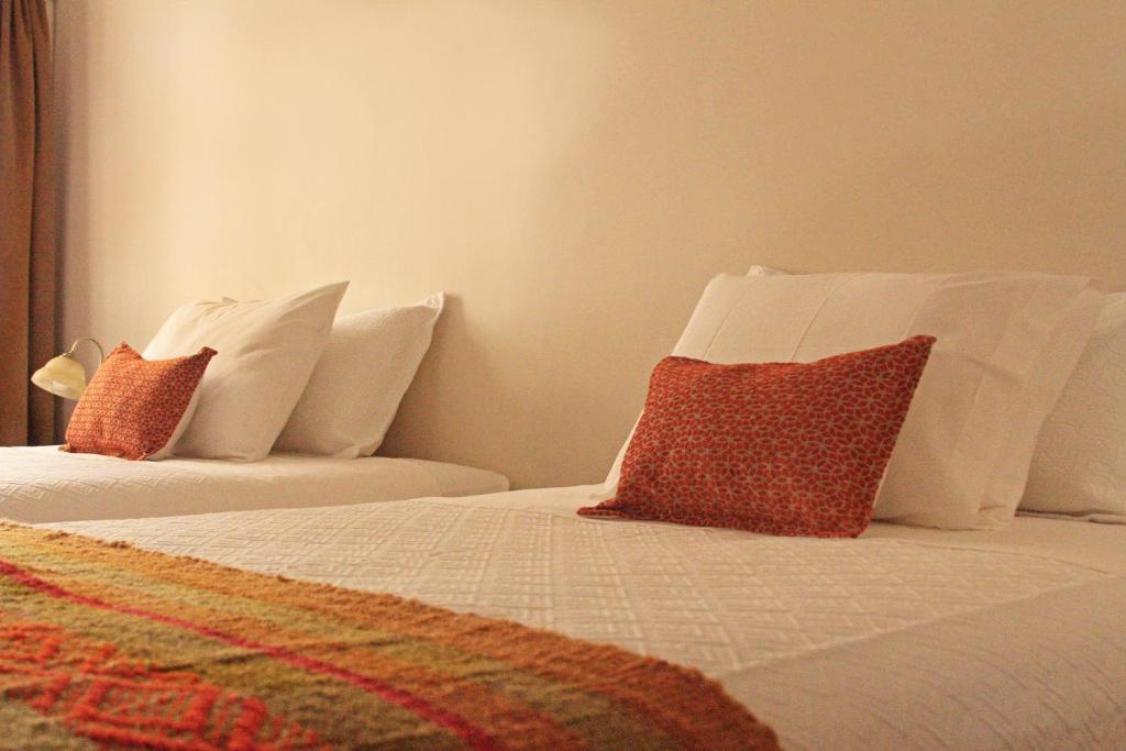 two beds with white pillows in a room at Hotel Boutique Casa Conde in Santiago