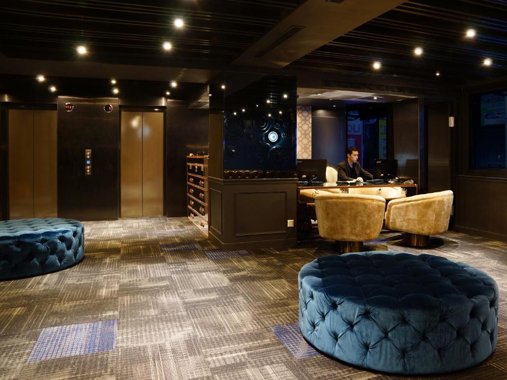 a man sitting at a desk in a room at Hotel Relax II in Taipei