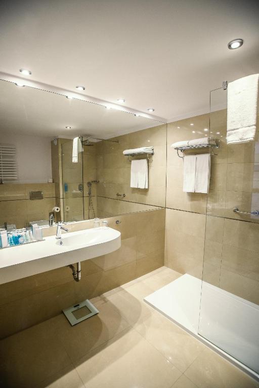 a bathroom with a sink and a shower at Grand Lubicz Uzdrowisko Ustka in Ustka