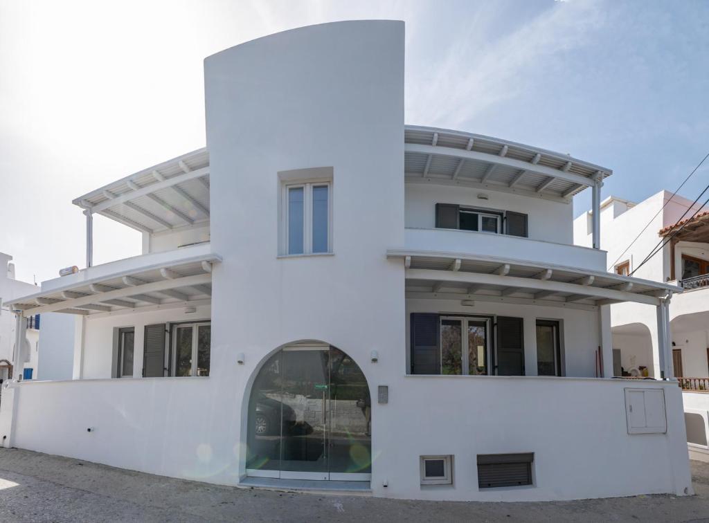 a white house with a round turret at Nissea Apartments in Naxos Chora