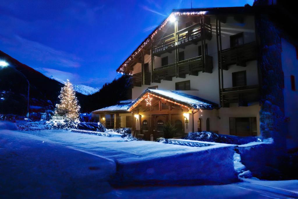 a building with a christmas tree in the snow at Albergo Castello in Valfurva