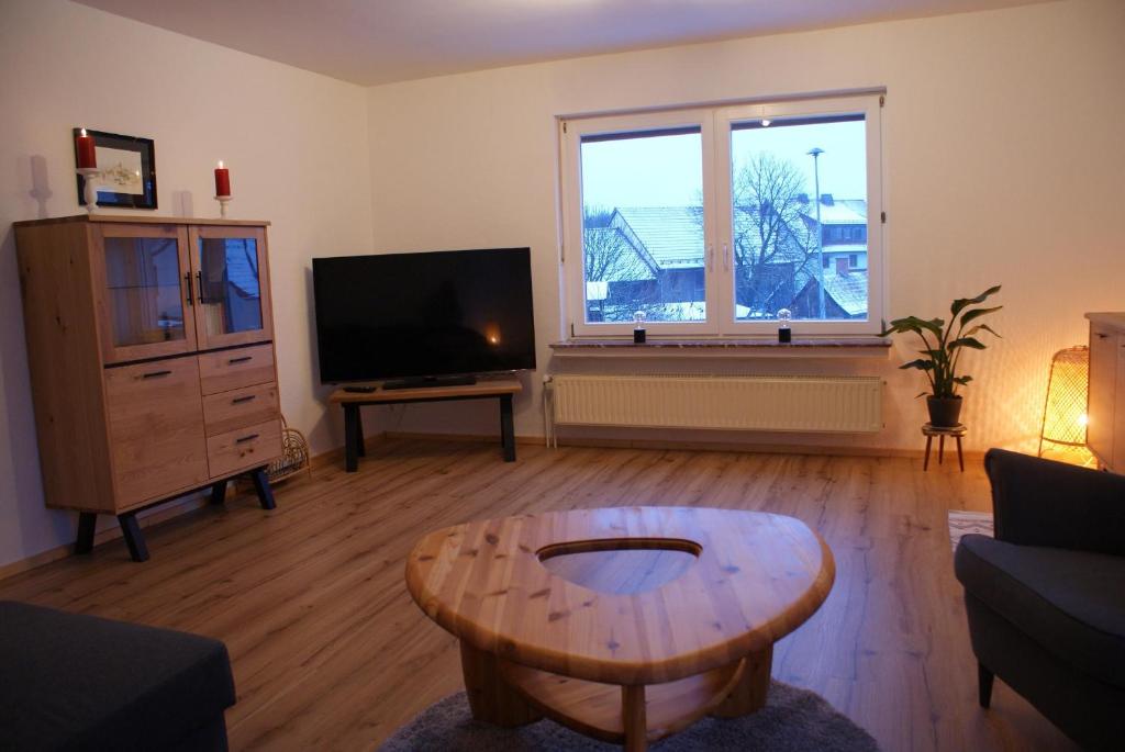 a living room with a coffee table and a flat screen tv at Ferienwohnung Zum Kirschhof in Hofbieber